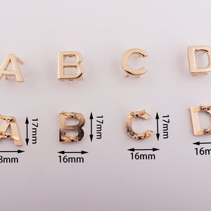 May include: Gold metal letter charms in the alphabet letters A, B, C, and D. The charms are 16mm to 18mm wide and 17mm tall.