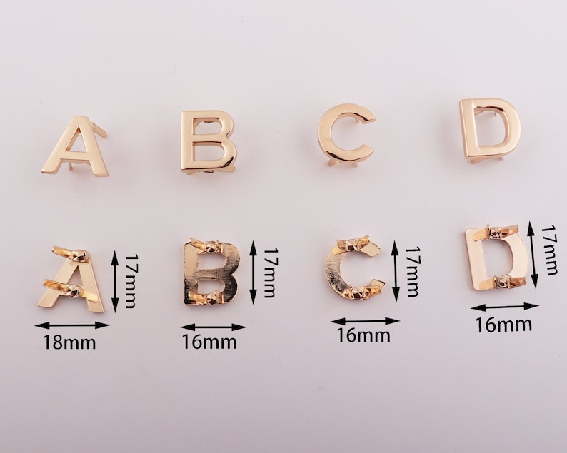 May include: Gold metal letter charms in the alphabet letters A, B, C, and D. The charms are 16mm to 18mm wide and 17mm tall.