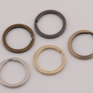 Op de afbeelding: Vijf verschillende sleutelringen in verschillende afwerkingen, waaronder zilver, goud en messing.
