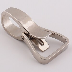 May include: Silver metal swivel trigger snap hook. The hook has a D-ring and a swiveling trigger.