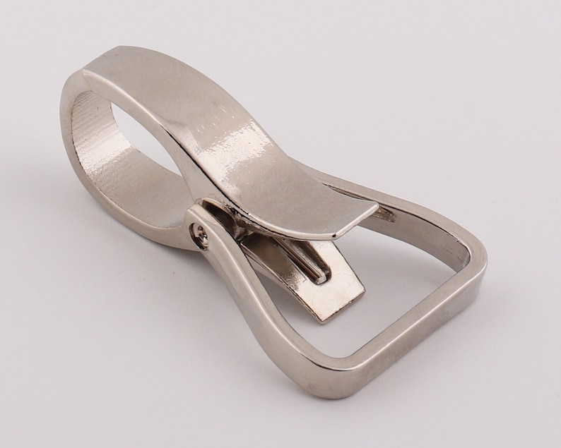 May include: Silver metal swivel trigger snap hook. The hook has a D-ring and a swiveling trigger.