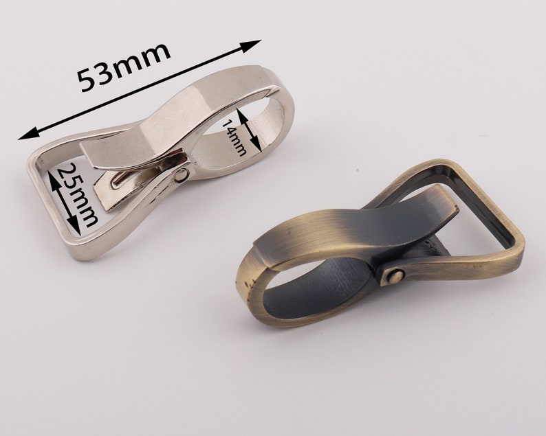 May include: Two metal swivel clasps, one silver and one antique brass. The silver clasp measures 2.5 inches by 5.3 inches. The antique brass clasp measures 2.5 inches by 5.3 inches.