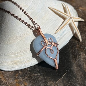 May include: A light blue heart-shaped stone pendant wrapped in copper wire with a delicate copper chain.