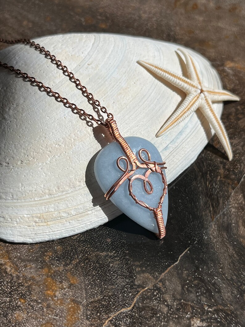 May include: A light blue heart-shaped stone pendant wrapped in copper wire with a delicate copper chain.