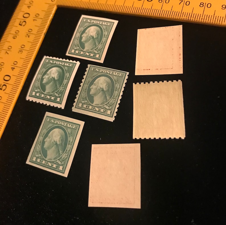 May include: Five vintage US postage stamps featuring a portrait of George Washington. The stamps are green and have the text "US POSTAGE 1 CENT" printed on them. There are also four blank stamps.