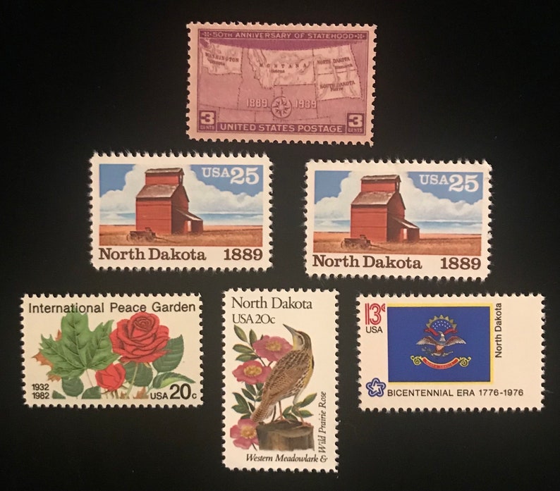 Pu&ograve; includere: Una collezione di francobolli vintage con immagini del Dakota del Nord, tra cui un elevatore di cereali, un giardino della pace, un'allodola dei prati e il sigillo dello stato. I francobolli sono del 50&deg; anniversario della stato, dell'era bicentenaria e degli anni '80.