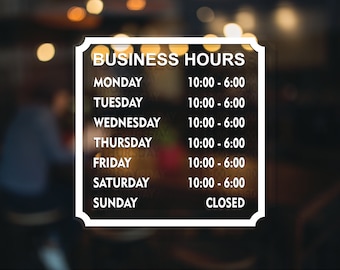 May include: White sign with black text listing business hours. The sign says "Business Hours" and lists the hours for each day of the week. Monday to Saturday the hours are 10:00 AM to 6:00 PM. Sunday is closed.
