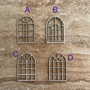 May include: Four wooden arched window frames with different pane designs. The frames are labeled A, B, C, and D.