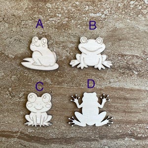 May include: Four unfinished wooden frog cutouts, labeled A, B, C, and D. The frogs are in various poses, with some sitting and others standing.