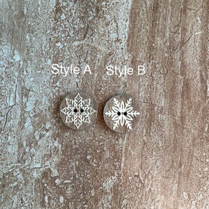 May include: Two wooden buttons with a snowflake design. The button on the left is labeled "Style A" and the button on the right is labeled "Style B".