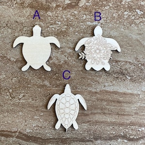 May include: Three wooden turtle shapes, one plain, one with a floral design, and one with a detailed shell design.