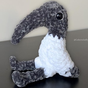 Peut inclure: Un modèle de crochet pour un ibis miniature, un petit oiseau au long bec. Le modèle est disponible en téléchargement sur Etsy. L'image montre un ibis crocheté en noir et blanc.