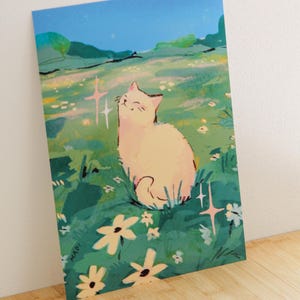 May include: A print featuring a smiling cat in a field of flowers under a blue sky. The cat is light-colored, and the flowers are white and yellow. The artwork has a whimsical, illustrative style.