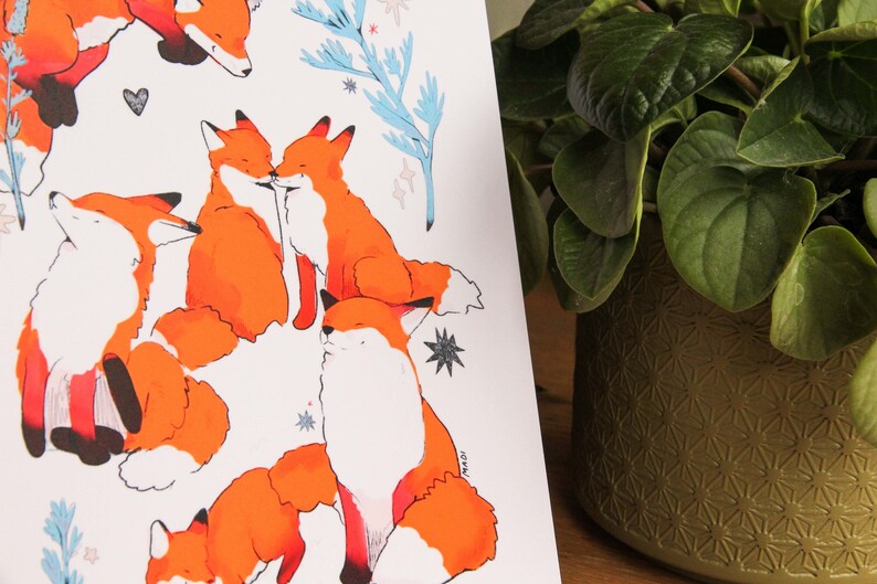 May include: A white background with a repeating pattern of orange foxes. The foxes are in various poses, including cuddling, sleeping, and sitting up. The background also features blue and white floral elements.