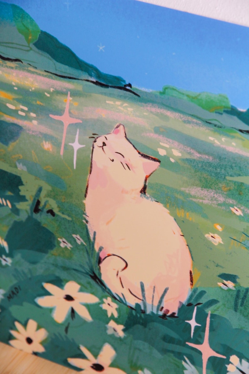 May include: An illustration of a white cat basking in the sun in a field of flowers. The cat is smiling with its eyes closed, surrounded by green grass and white flowers. The sky is blue with a few stars and the word "MADI" is in the bottom left corner.