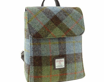 Könnte beinhalten: Ein blauer, grüner und brauner karierter Tweed-Rucksack mit einem braunen Lederriemen und einem kleinen Etikett mit der Aufschrift "Harris Tweed."
