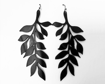 May include: A pair of black dangle earrings with a leaf design. The earrings are made of a lightweight material and have a delicate, feminine look.