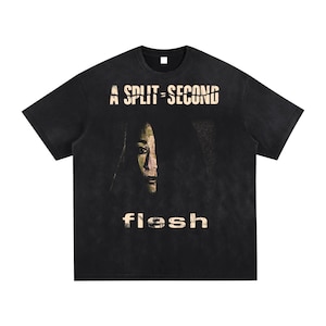 May include: Black t-shirt featuring the text "A Split-Second" above a faded face image and the word "flesh" below. The shirt has a vintage, distressed appearance.