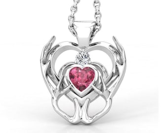 May include: Silver heart pendant necklace with a pink heart-shaped gemstone and a smaller clear gemstone in the center.