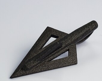 May include: Black arrowhead with a triangular design and a textured surface.