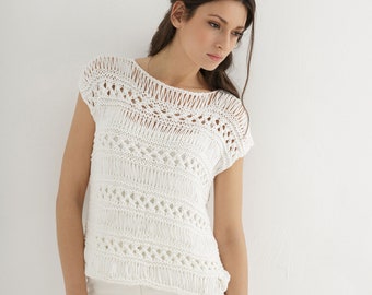 May include: White crochet top with a delicate openwork pattern. The top has a round neckline and short sleeves.