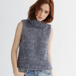 May include: A grey sleeveless turtleneck sweater with a speckled pattern.