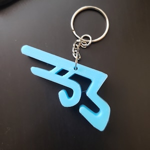May include: A light blue plastic keychain shaped like a stylized number 35. The keychain is attached to a silver metal ring and chain.