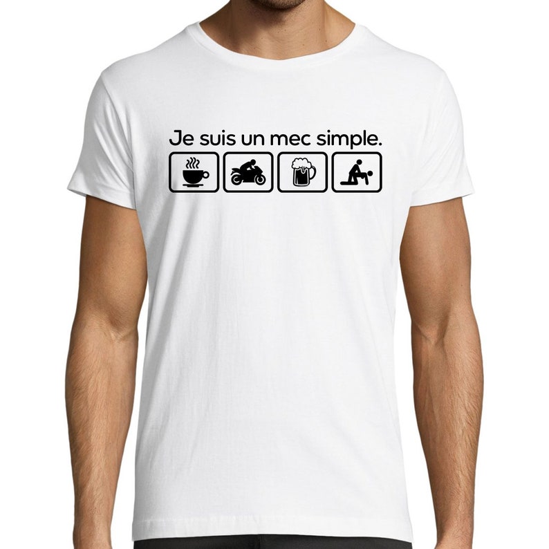 May include: White t-shirt with black text that reads "Je suis un mec simple."  The text is surrounded by four icons: a cup of coffee, a motorcycle, a beer mug, and a couple.