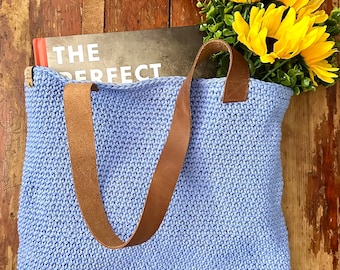 Handmade periwinkle/blue cotton knit/crochet tote bag with linen lining and leather straps. Approximately 14x14 inches.