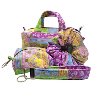 May include: A set of colorful fabric accessories, including a small handbag, a cosmetic bag, a scrunchie, and a wrist strap. The items feature a floral pattern in shades of purple, yellow, green, and blue. The handbag has a top handle and a zipper closure.