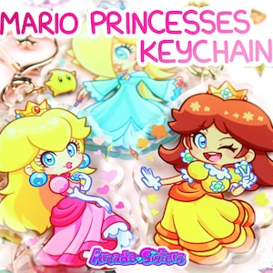 Peut inclure: Porte-clés avec des illustrations de dessins animés de la Princesse Peach, Rosalina et la Princesse Daisy de la série de jeux vidéo Mario. Les porte-clés ont un fond transparent et sont décorés de cœurs et d'étoiles. Le texte "MARIO PRINCESSES KEYCHAIN" est affiché en haut.