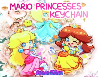 May include: Keychains featuring cartoon illustrations of Princess Peach, Rosalina, and Princess Daisy from the Mario video game series. The keychains have a clear background and are decorated with hearts and stars. The text "MARIO PRINCESSES KEYCHAIN" is displayed at the top.