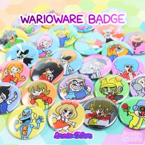 Peut inclure: Une collection de badges de personnages WarioWare colorés. Chaque badge rond présente une illustration de personnage différente sur un fond vibrant. Le texte "WARIOWARE BADGE" est affiché en haut. Le logo Arcade Sisters est en bas.