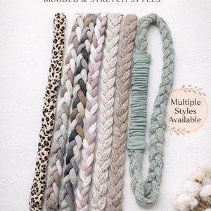 May include: A collection of soft fabric headbands featuring braided and stretch styles in various colors and patterns, including leopard print, grey, pink, and sage green. The text reads Soft Fabric Headbands, Braided & Stretch Styles, Multiple Styles Available, Comfortable, Stretchy, Everyday.