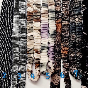 Puede incluir: Una selecci&oacute;n de ocho coleteros de tela en varios patrones y colores. Los coleteros incluyen dise&ntilde;os en rojo oscuro, rayas blancas y negras, marr&oacute;n y blanco, morado y blanco, y estampados de animales en negro y marr&oacute;n.