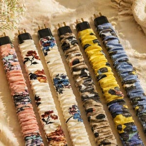 May include: An assortment of decorative power cord covers in various patterns and colors, including floral, animal print, and solid colors. Each cover is approximately 12 inches long, with a black plug at the top. The cords are arranged on a neutral-toned surface.