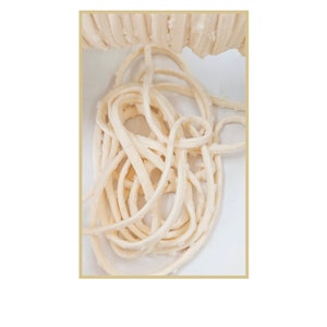 May include: A close-up of a pile of white cotton cord, the cord is twisted and piled on top of itself.