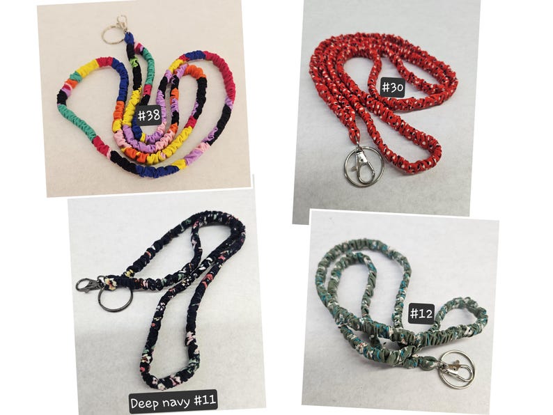 K&ouml;nnte beinhalten: Vier Stoff-Lanyards mit Metall-Schl&uuml;sselringen und Karabinerverschl&uuml;ssen. Lanyard #38 zeigt ein mehrfarbiges Patchwork-Muster. Lanyard #30 ist rot mit wei&szlig;en Punkten. Lanyard #11 ist tief dunkelblau mit Blumenmuster. Lanyard #12 ist gr&uuml;n mit Blumenmuster.