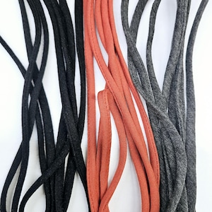 May include: Three bundles of cord, one black, one red, and one gray. The cords are all made of a soft, textured material.
