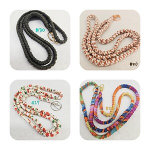 Op de afbeelding: Vier stoffen lanyards met metalen sluitingen. Nummer 30 is effen zwart. Nummer 20 is een bruin en wit patroonkoord. Nummer 17 heeft een witte stof met een rode en groene bloemenprint. Nummer 25 is een meerkleurig koord met diverse tinten.