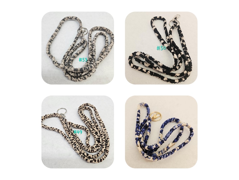 K&ouml;nnte beinhalten: Vier Stoff-Lanyards mit Metallringen. Oben links ein grau-wei&szlig;es Muster, oben rechts ein schwarz-wei&szlig;es Muster mit #50, unten links ein beigefarbenes Leopardenmuster mit #49 und unten rechts ein blau-wei&szlig;es Muster.