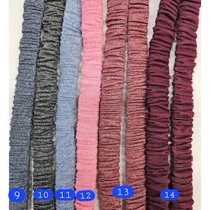 Puede incluir: Una selecci&oacute;n de bandas el&aacute;sticas en varios colores, incluyendo azul marino, carb&oacute;n, azul claro, rosa y burdeos. Cada banda est&aacute; fruncida, creando una apariencia texturizada. Los n&uacute;meros 9 a 14 son visibles en las bandas.
