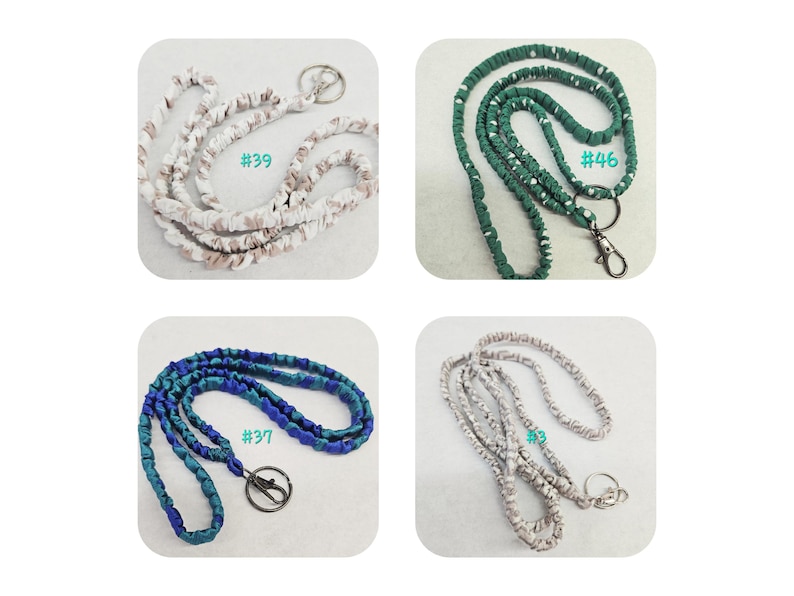K&ouml;nnte beinhalten: Vier Stoff-Lanyards mit Metall-Schl&uuml;sselringen und Karabinerverschl&uuml;ssen. Oben links #39 ist beige und wei&szlig;. Oben rechts #46 ist dunkelgr&uuml;n mit wei&szlig;en Punkten. Unten links #37 ist blau und blaugr&uuml;n. Unten rechts #3 ist grau und wei&szlig; marmoriert.