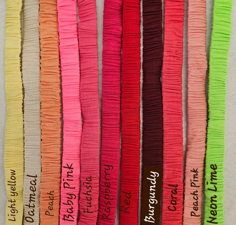 May include: Eleven vertical fabric strips in various colors, each featuring a gathered, textured surface. The colors are labeled as light yellow, oatmeal, peach, baby pink, fuchsia, raspberry, red, burgundy, coral, peach pink, and neon lime.
