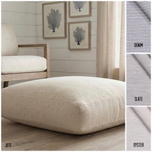 Peut inclure: Un grand pouf carré en jute avec un motif à rayures crème et beige. Le pouf est posé sur un sol en bois, avec une chaise assortie et des œuvres d'art encadrées en arrière-plan. Des échantillons de tissu denim, ardoise et huître sont présentés.