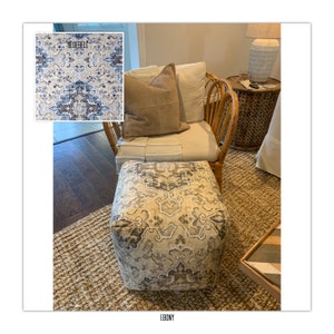 May include: A beige and gray patterned ottoman with a woven rug underneath. The ottoman is in front of a wicker chair with a beige cushion and a brown throw pillow. The text "BLUEBELL" is visible in the upper left corner of the image.