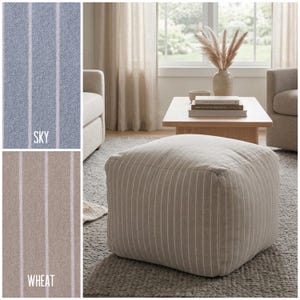 Könnte beinhalten: Ein quadratischer Stoff-Pouffe mit vertikalem Nadelstreifenmuster in einem neutralen Weizenton. Das Design enthält zwei Einsätze, die denselben gestreiften Stoff in Himmelblau und Weizen zeigen, jeweils beschriftet mit dem Farbnamen.