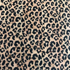 K&ouml;nnte beinhalten: Nahaufnahme einer Korkplatte mit Leopardenmuster. Das Muster zeigt schwarze Flecken auf hellbraunem Hintergrund. Das Korkmaterial hat eine strukturierte Oberfl&auml;che.