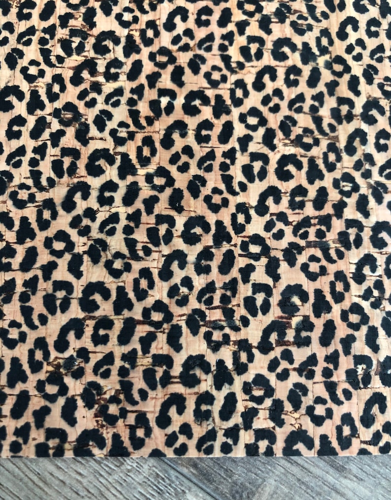 K&ouml;nnte beinhalten: Nahaufnahme einer Korkplatte mit Leopardenmuster. Das Muster zeigt schwarze Flecken auf hellbraunem Hintergrund. Das Korkmaterial hat eine strukturierte Oberfl&auml;che.