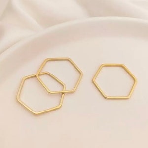 May include: Two gold hexagon rings, one larger than the other, on a white background.